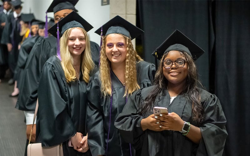ACA students in their cap and gown preparing to walk