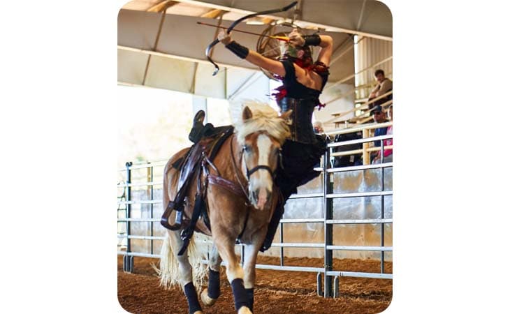 Brenna from Alabama Connections Academy stunting on her horse with a bow and arrow. 