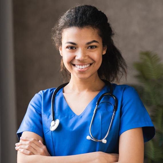 A women wearing blue scrubs and a stethoscope