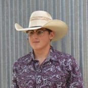 Tate smiling wearing a cowboy hat